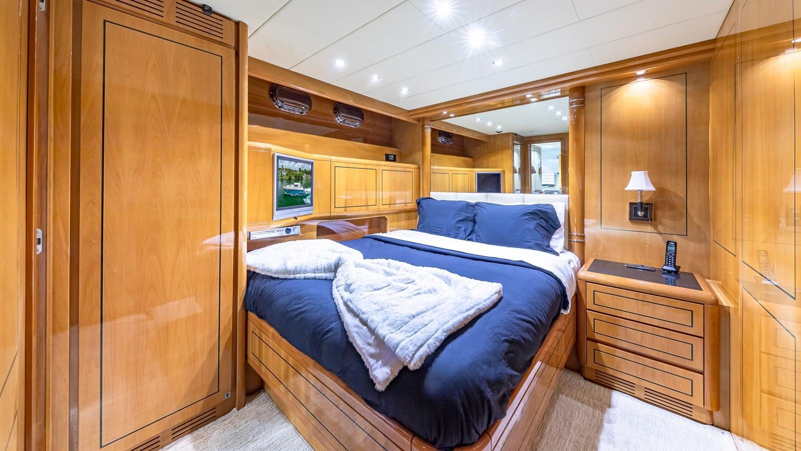 a bedroom with a bed and a wood door aboard HAPPY Yacht for Sale