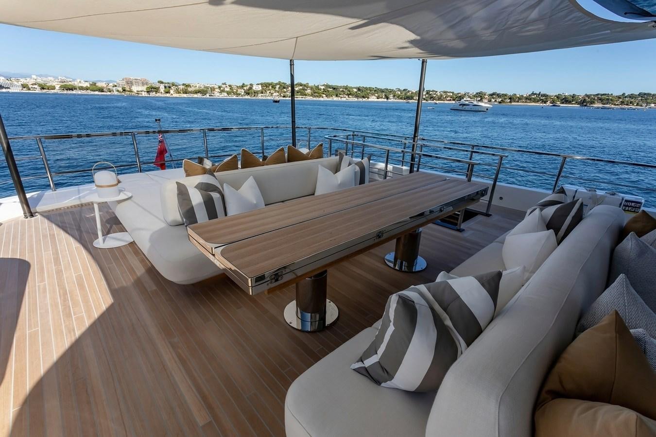a couch and a table on a deck overlooking a body of water aboard ADELLA Yacht for Sale