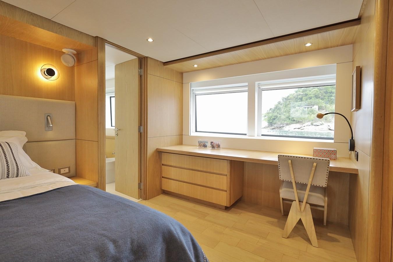 a bedroom with a desk and a bed aboard WAIKIKI Yacht for Sale