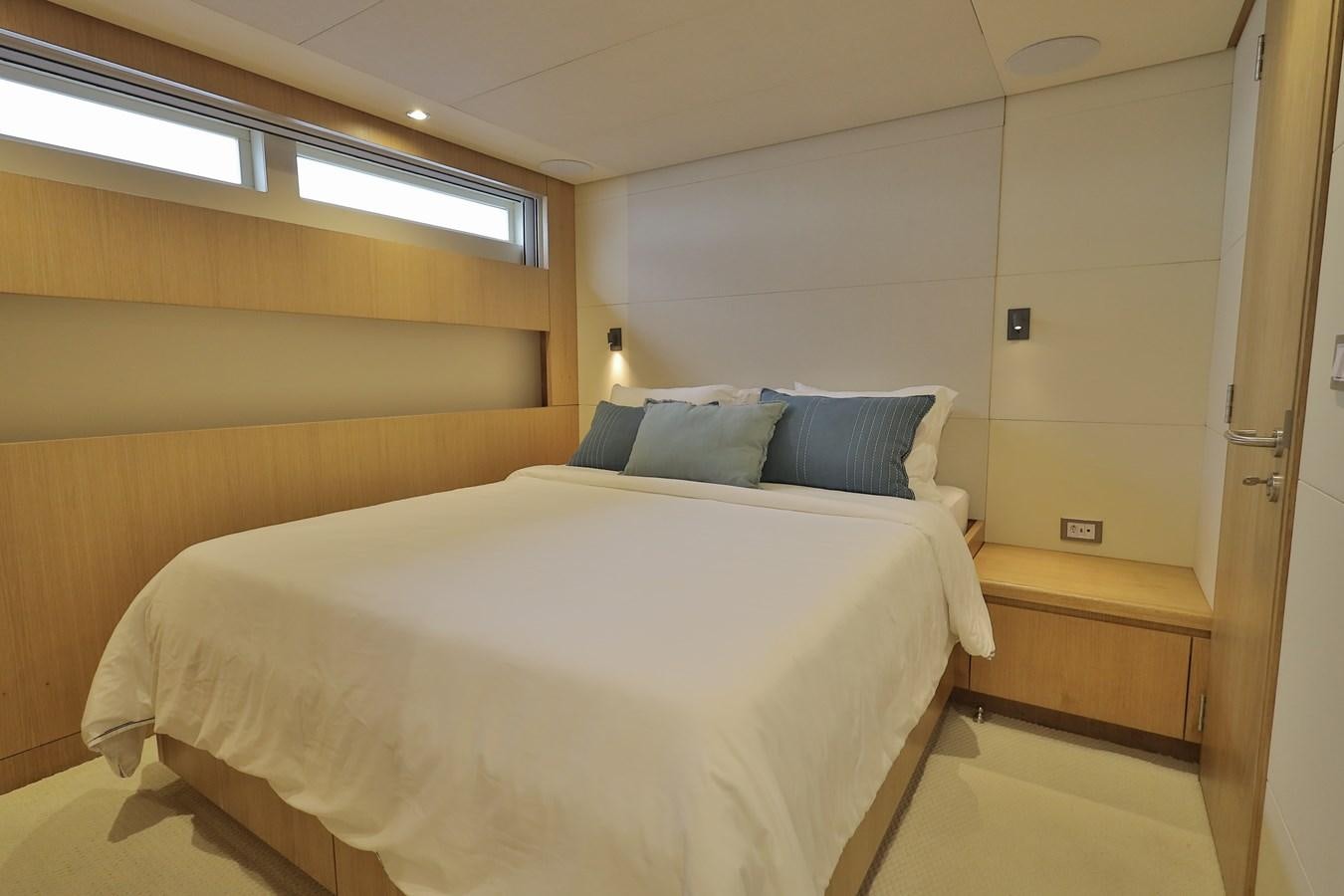 a bed with blue pillows aboard WAIKIKI Yacht for Sale