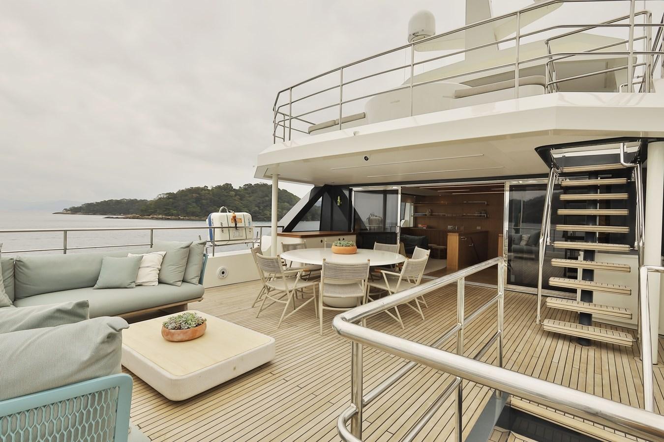 a deck with a couch and a table and chairs aboard WAIKIKI Yacht for Sale