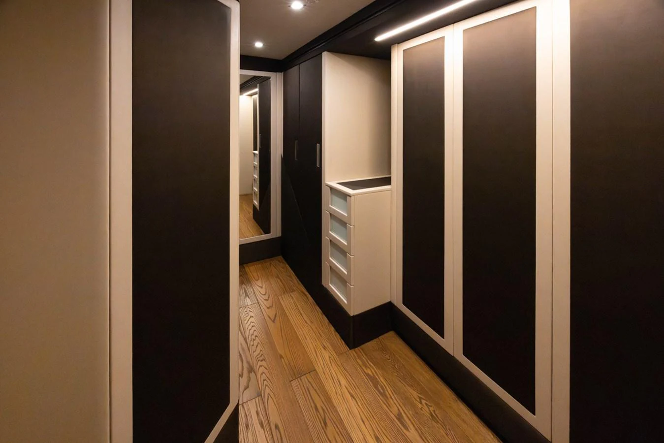 a hallway with a wood floor and cabinets aboard KANDO Yacht for Sale