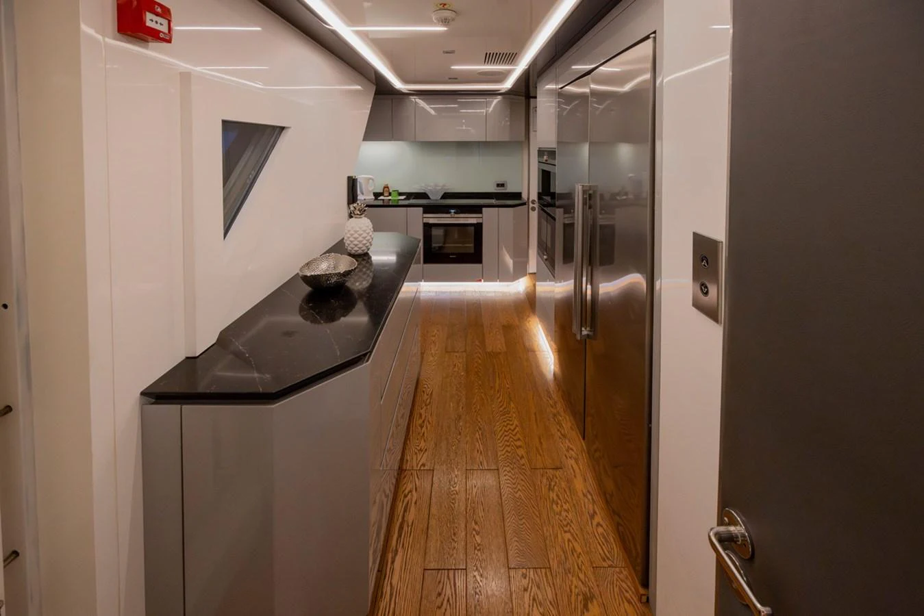 a long hallway with a desk and a computer on the wall aboard KANDO Yacht for Sale