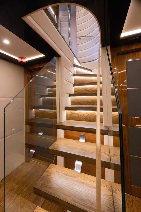 a wooden staircase with a metal railing aboard KANDO Yacht for Sale