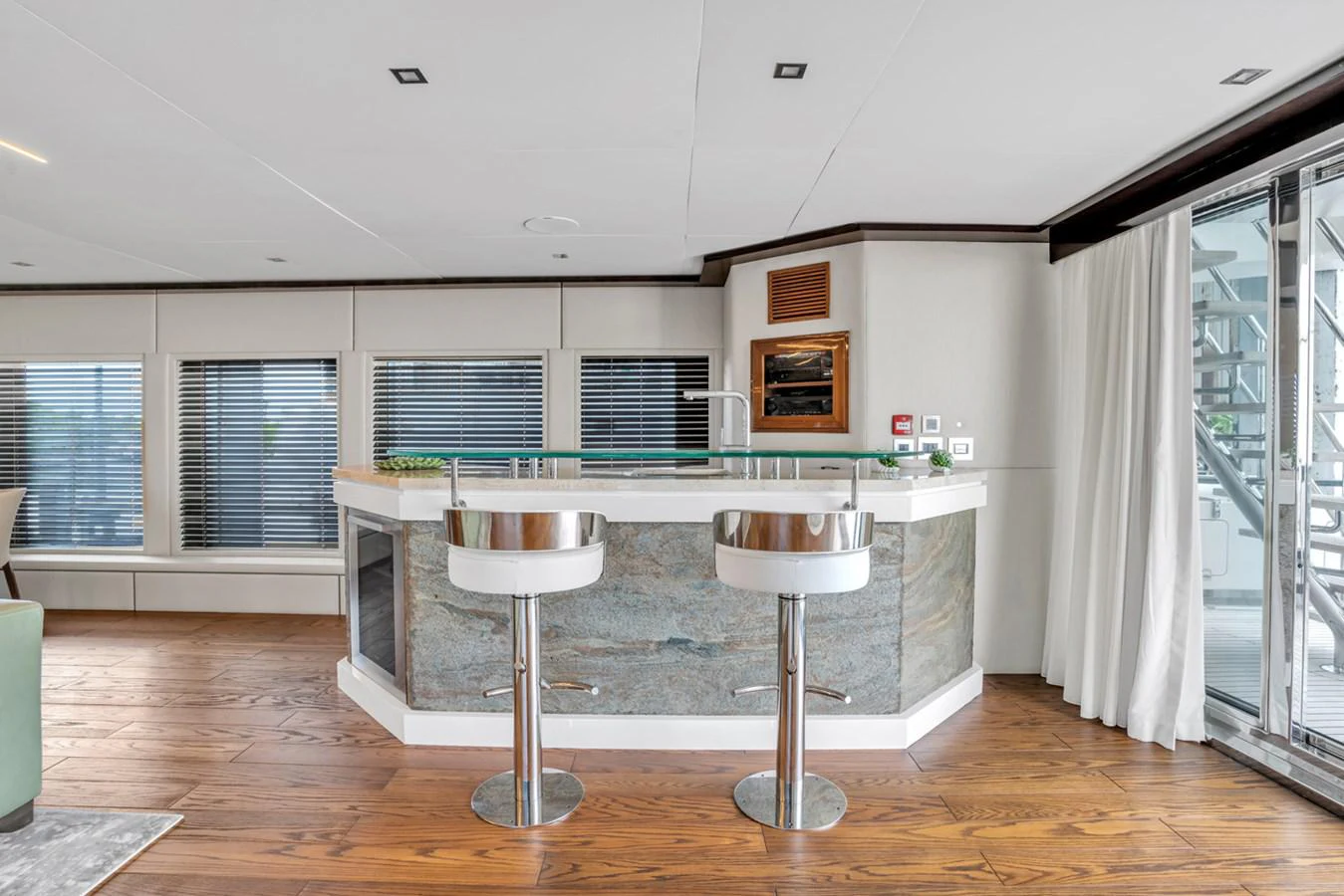 a kitchen with a table and stools aboard KANDO Yacht for Sale