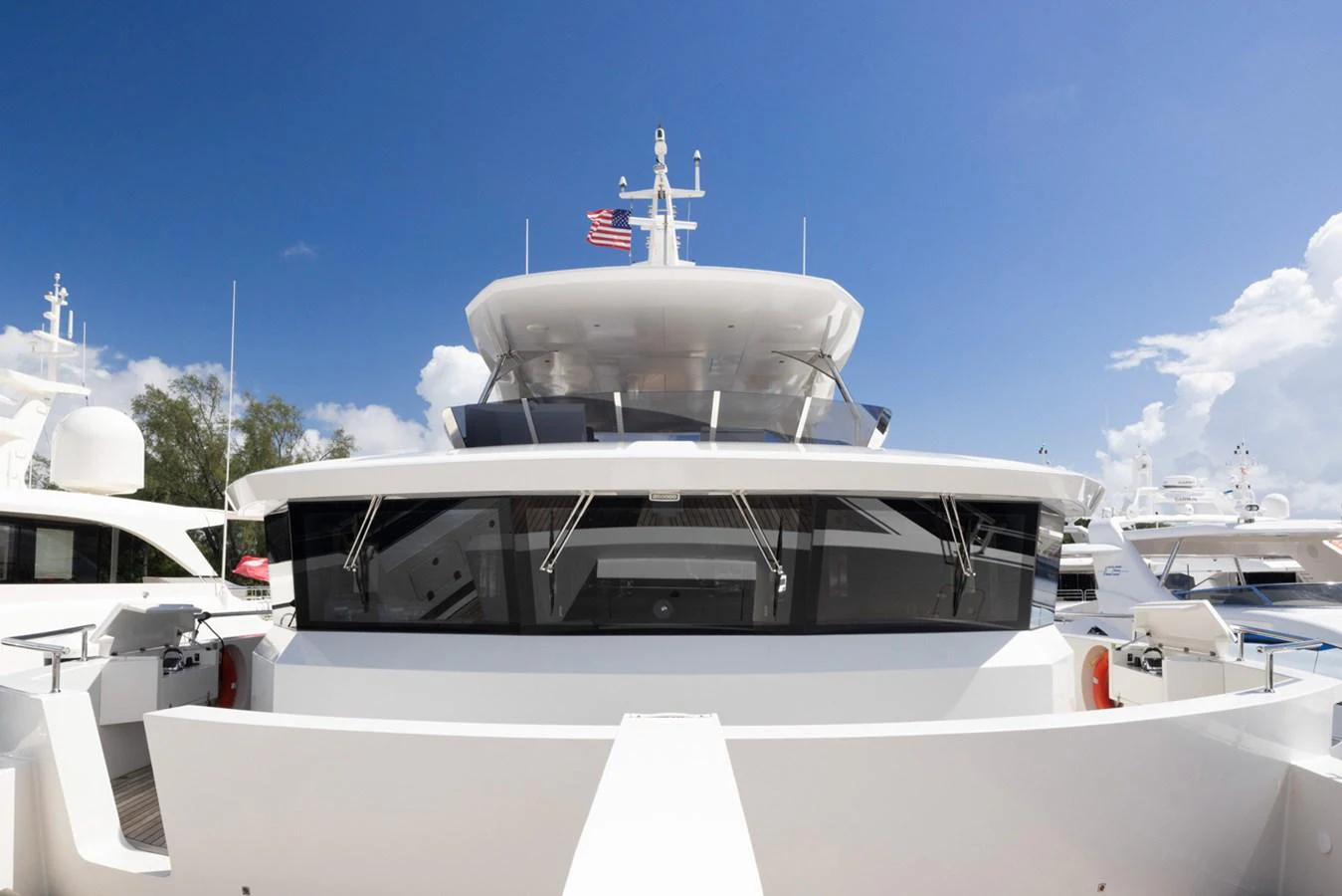 a white boat with a flag on it aboard KANDO Yacht for Sale
