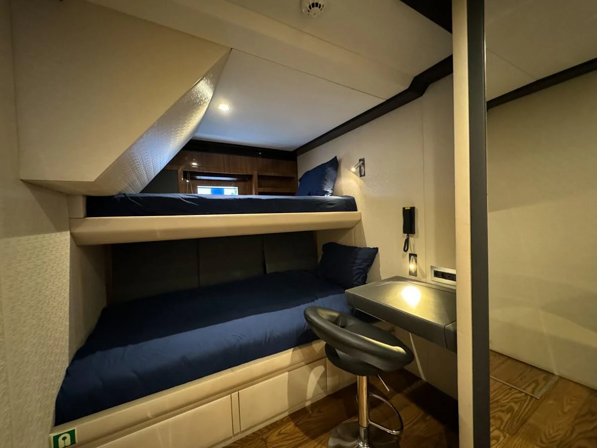 a room with a bed and desk aboard KANDO Yacht for Sale