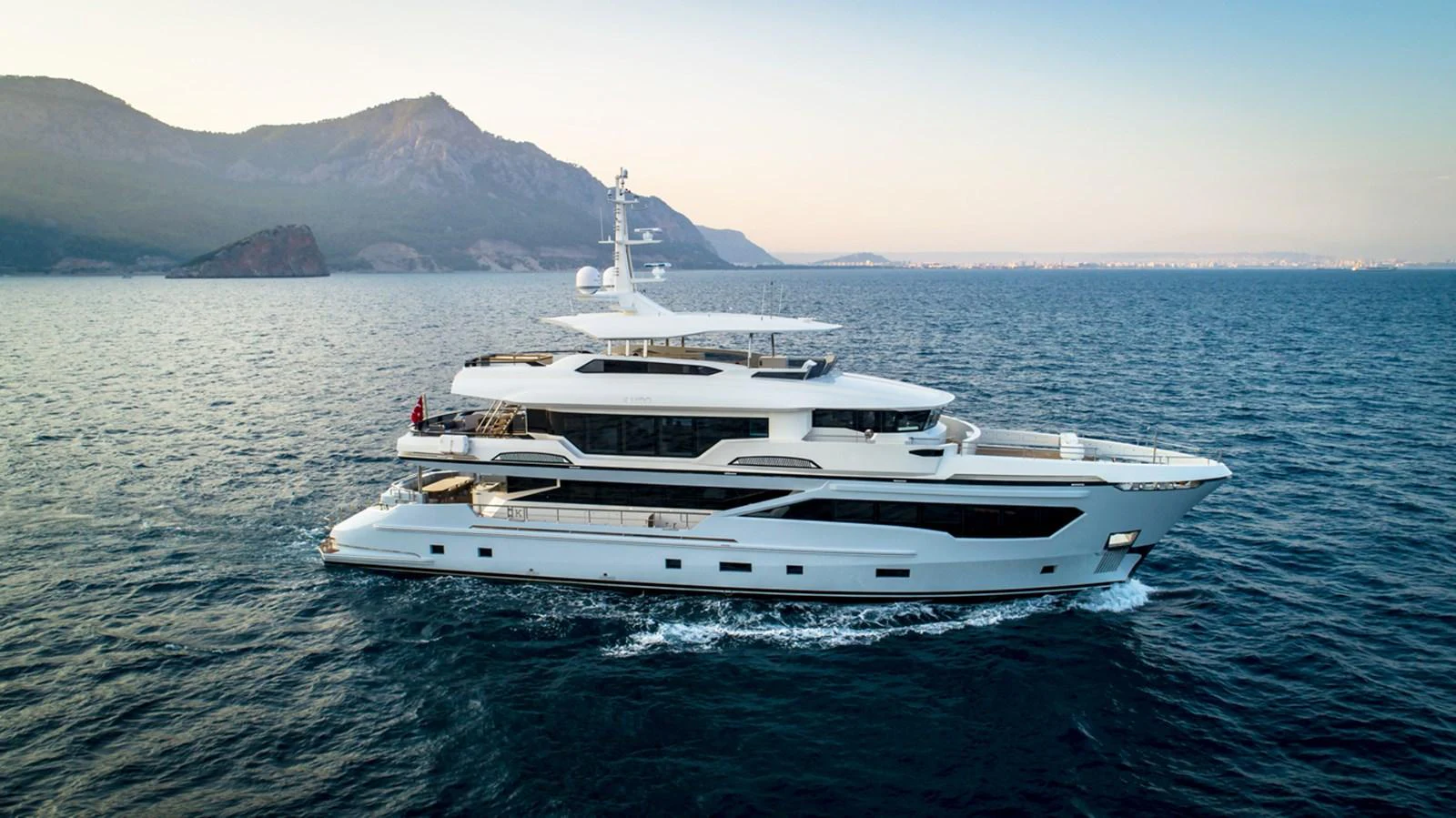 a white yacht in the water aboard KANDO Yacht for Sale