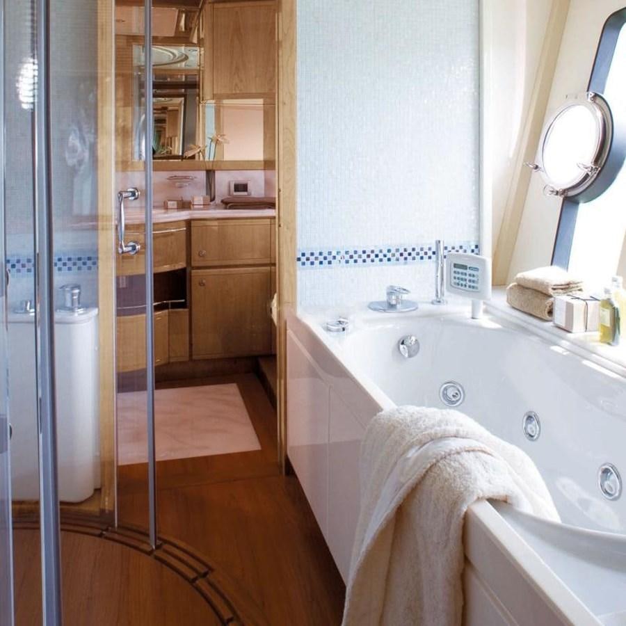 a bathroom with a tub sink and cabinets aboard NACL Yacht for Sale