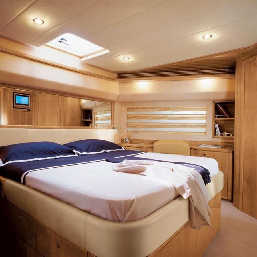 a room with a bed and a window aboard NACL Yacht for Sale