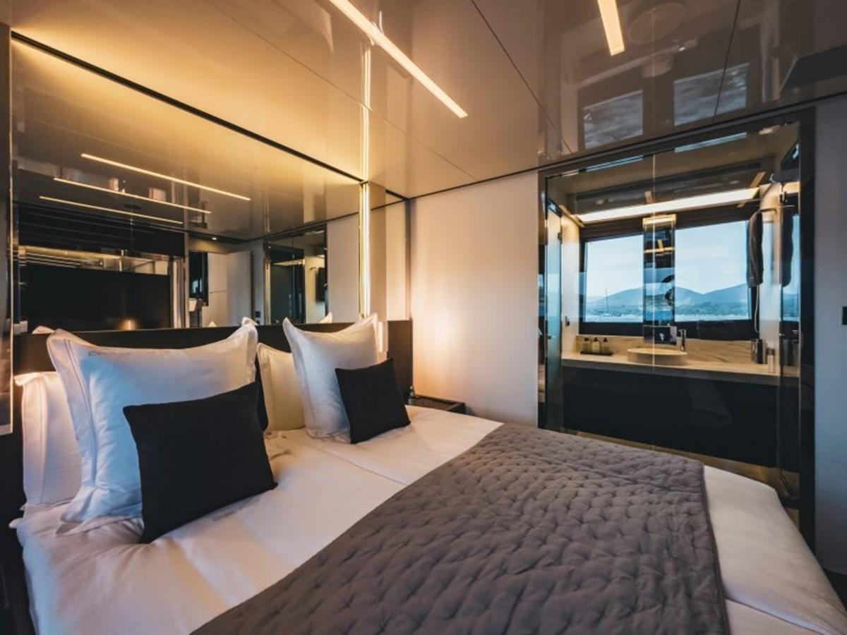 a bed with pillows and a large mirror in a room aboard NO Yacht for Sale