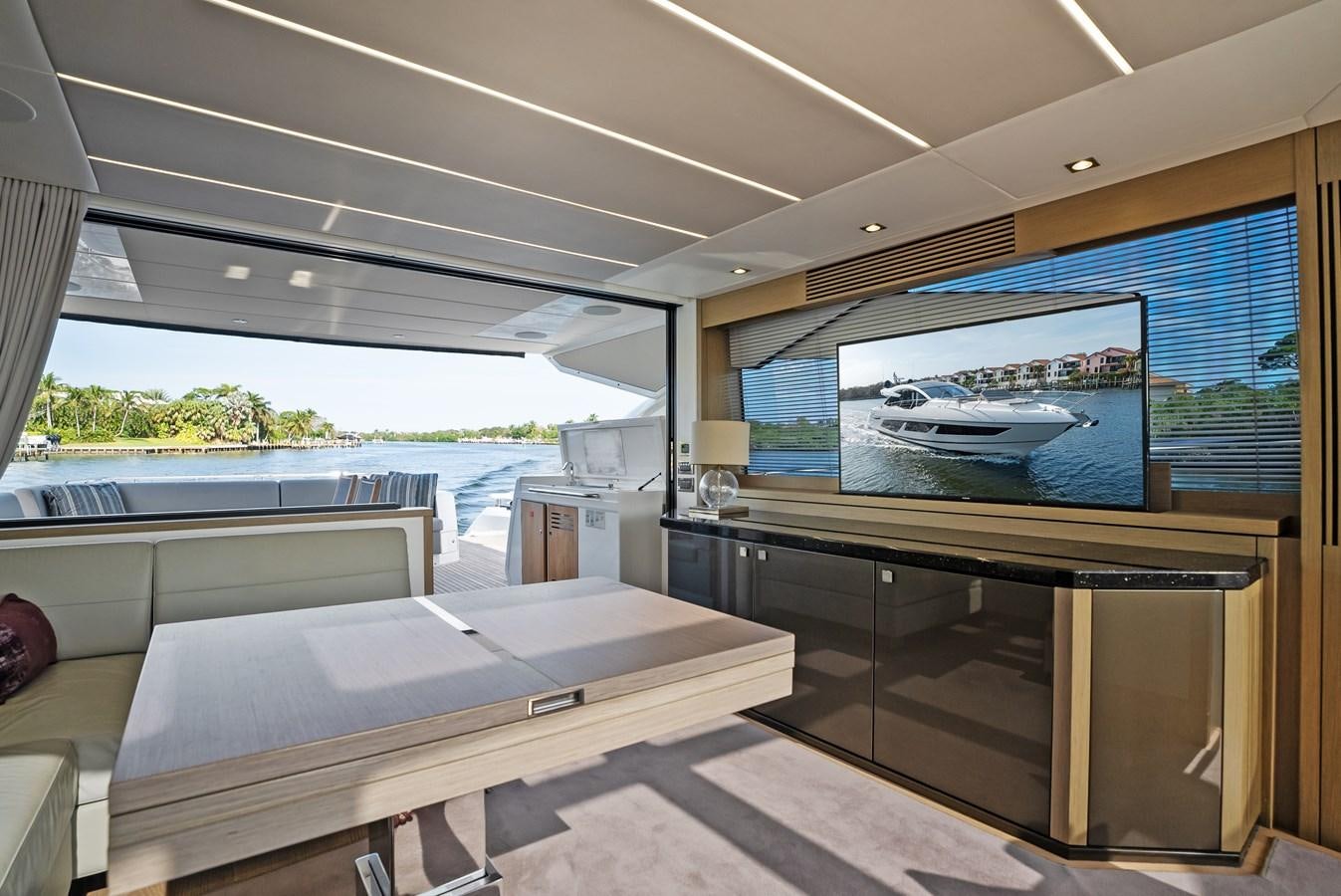 a room with a large window and a table with chairs and a television aboard IT'S A GIRL Yacht for Sale