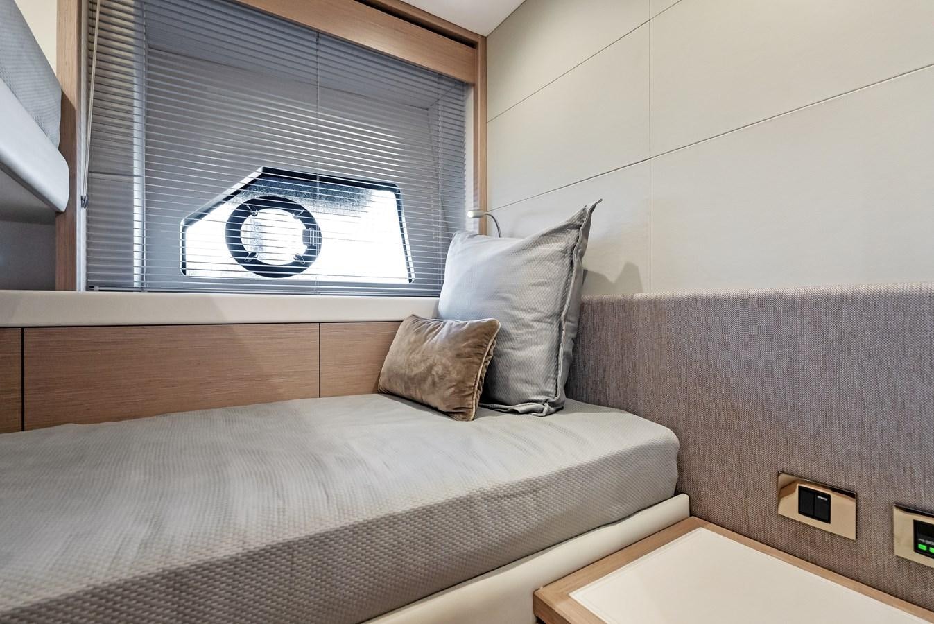 a bed with a pillow and a window aboard IT'S A GIRL Yacht for Sale