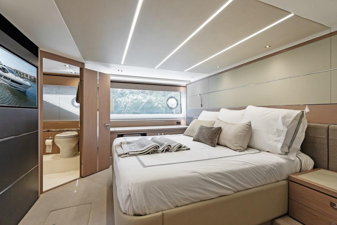 a bedroom with a bed and a window aboard IT'S A GIRL Yacht for Sale