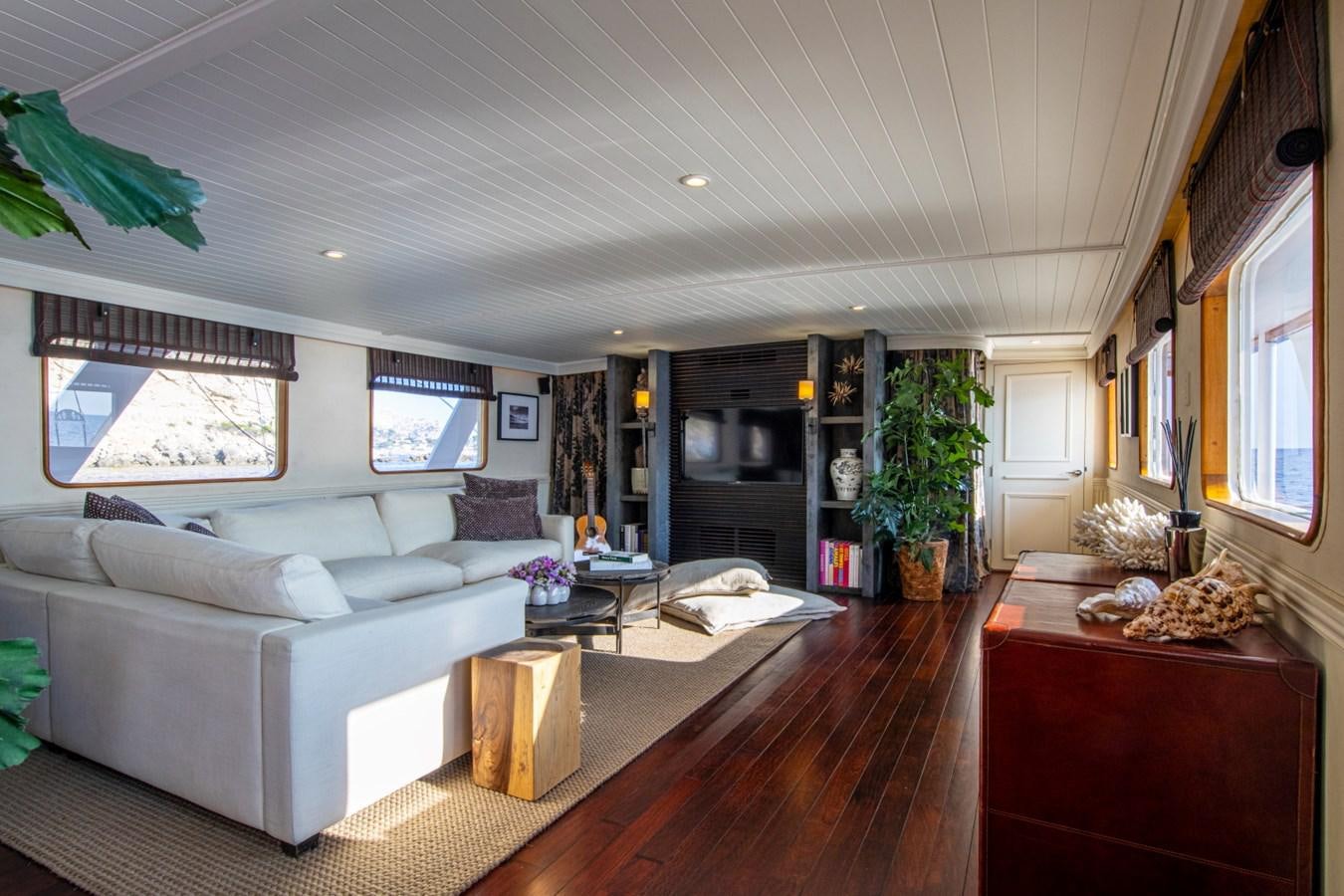 a living room with a large white couch and a wood floor aboard SANTA MARIA Yacht for Sale