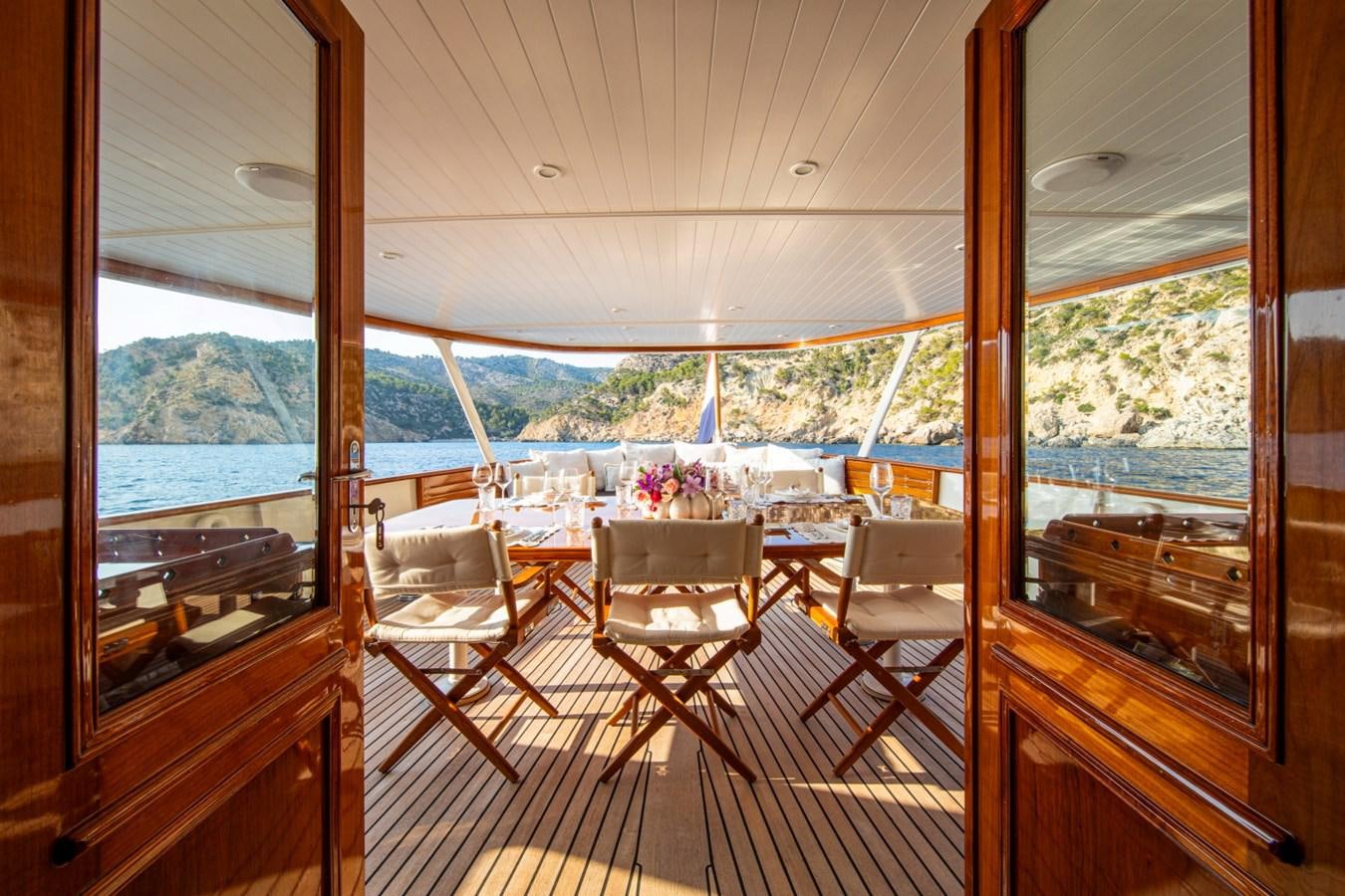 a deck with a view of the water and mountains aboard SANTA MARIA Yacht for Sale