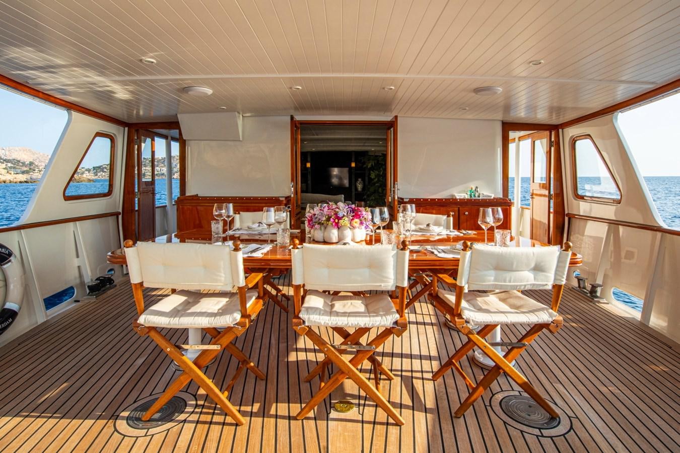 a room with tables and chairs aboard SANTA MARIA Yacht for Sale