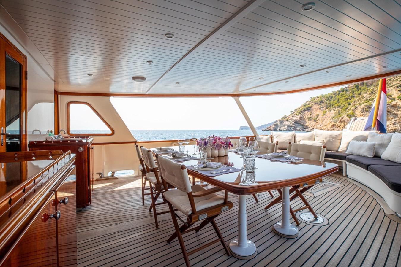 a large room with a table and chairs and a large window aboard SANTA MARIA Yacht for Sale
