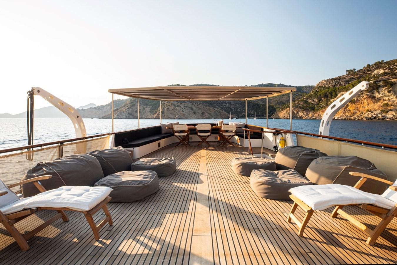 a deck with a deck and chairs on it aboard SANTA MARIA Yacht for Sale