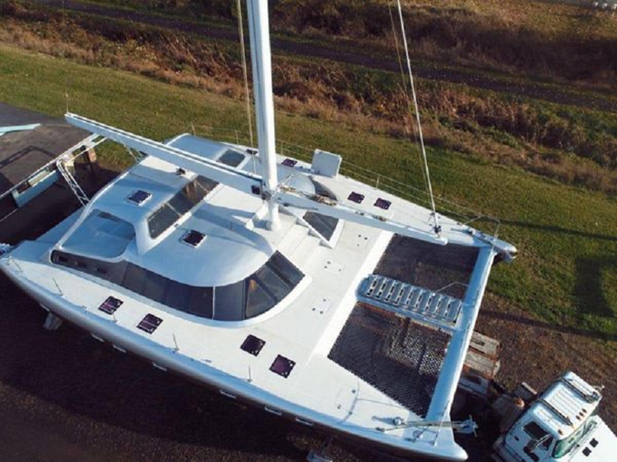 a white boat on a dock aboard 2023 PEDIGREE CAT SHUTTLEWORTH 52 AERO RIG Yacht for Sale