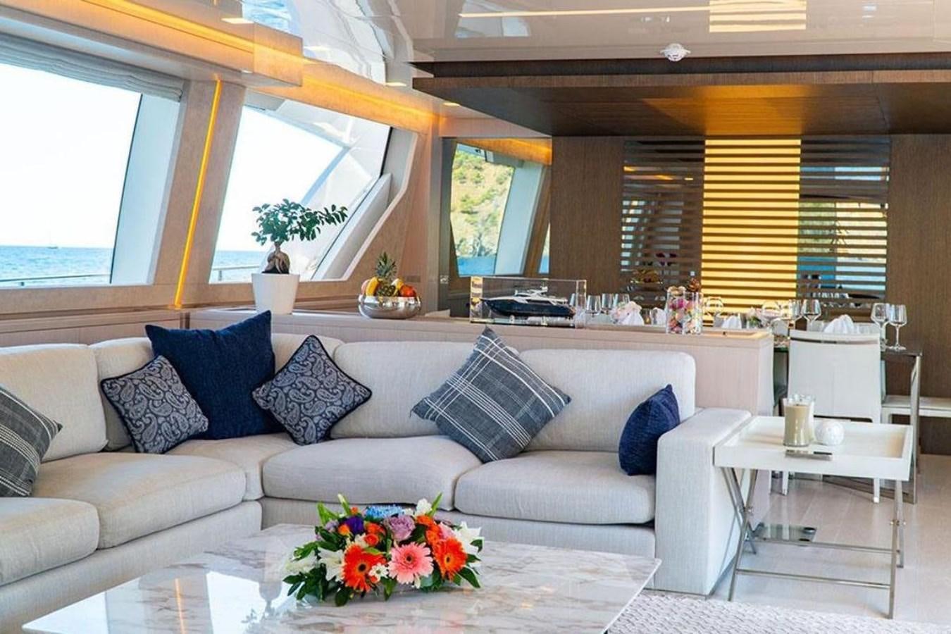 a living room with a couch and a table aboard CUSTOM LINE  97 Yacht for Sale