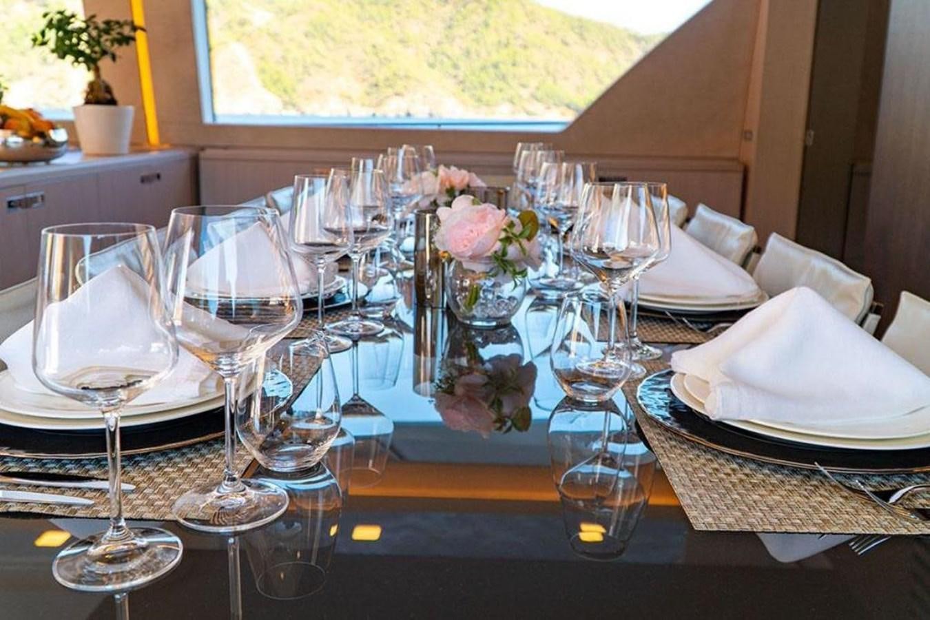a table with wine glasses and plates aboard CUSTOM LINE  97 Yacht for Sale