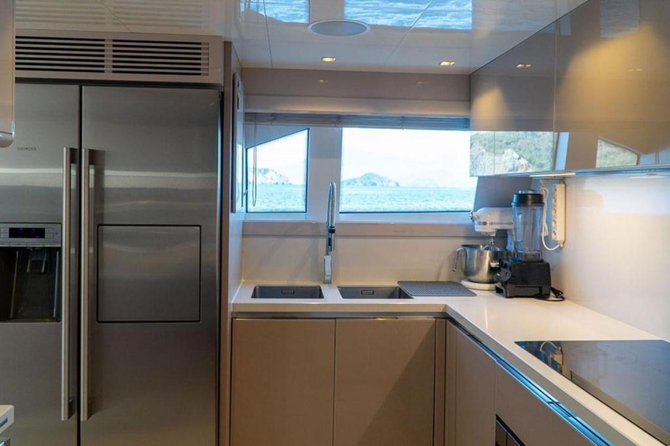 a kitchen with a refrigerator and a sink aboard CUSTOM LINE  97 Yacht for Sale