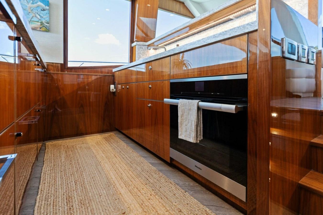 a kitchen with wooden cabinets aboard MANA Yacht for Sale