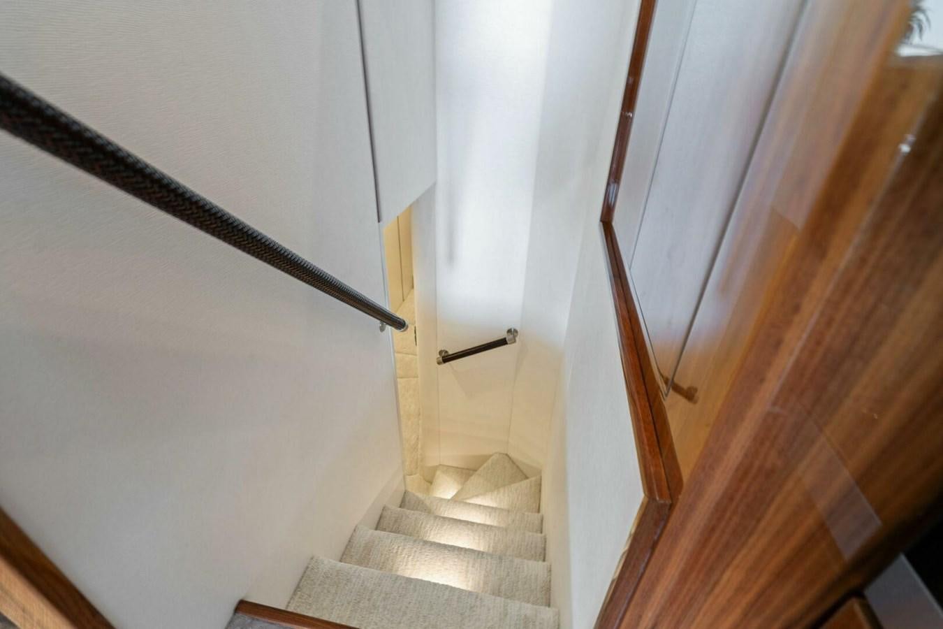 a staircase with white walls aboard MANA Yacht for Sale