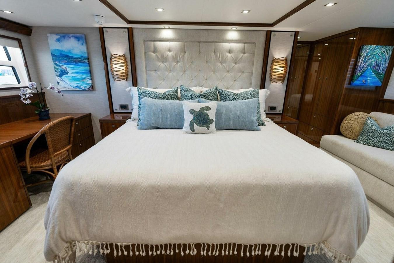 a bed with blue and white pillows aboard MANA Yacht for Sale