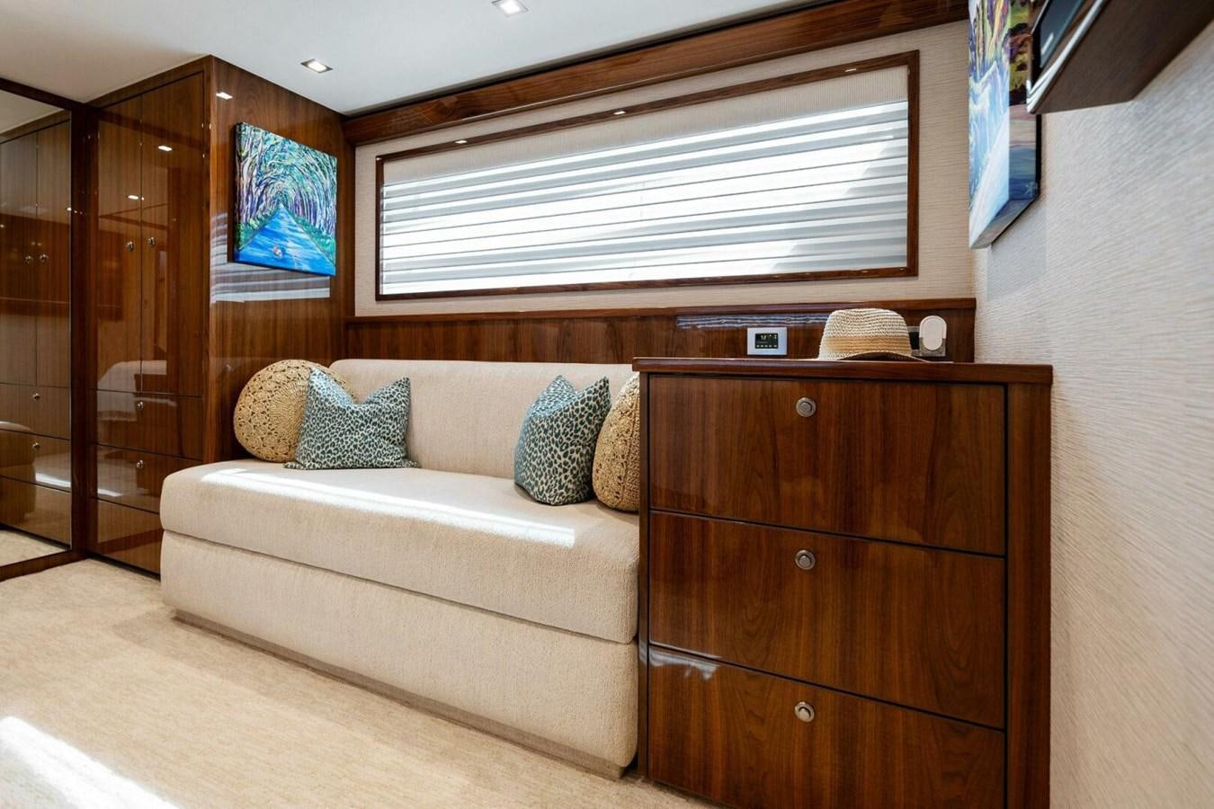 a living room with a couch and a wood cabinet aboard MANA Yacht for Sale