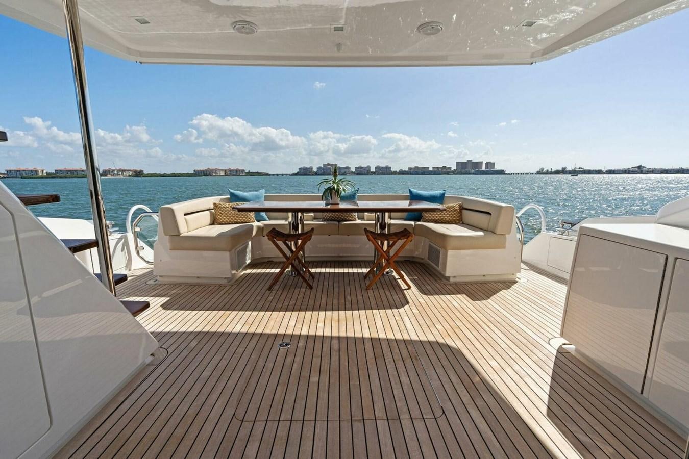 a deck with a table and chairs on it aboard MANA Yacht for Sale