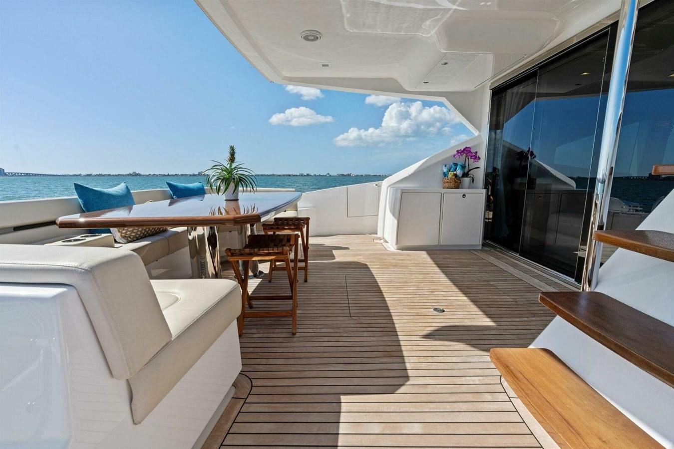a room with a large balcony overlooking the ocean aboard MANA Yacht for Sale