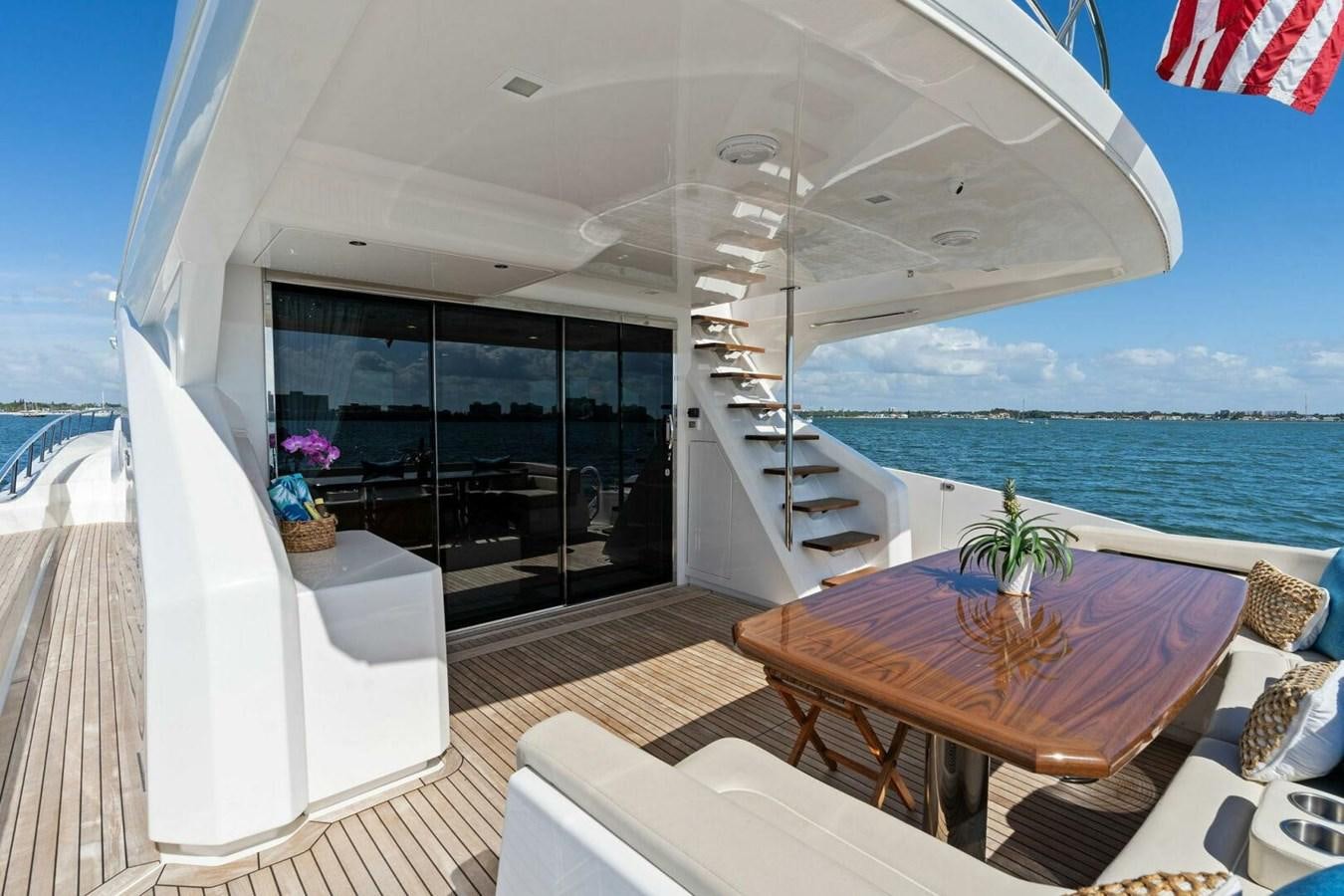 a balcony with a table and chairs aboard MANA Yacht for Sale