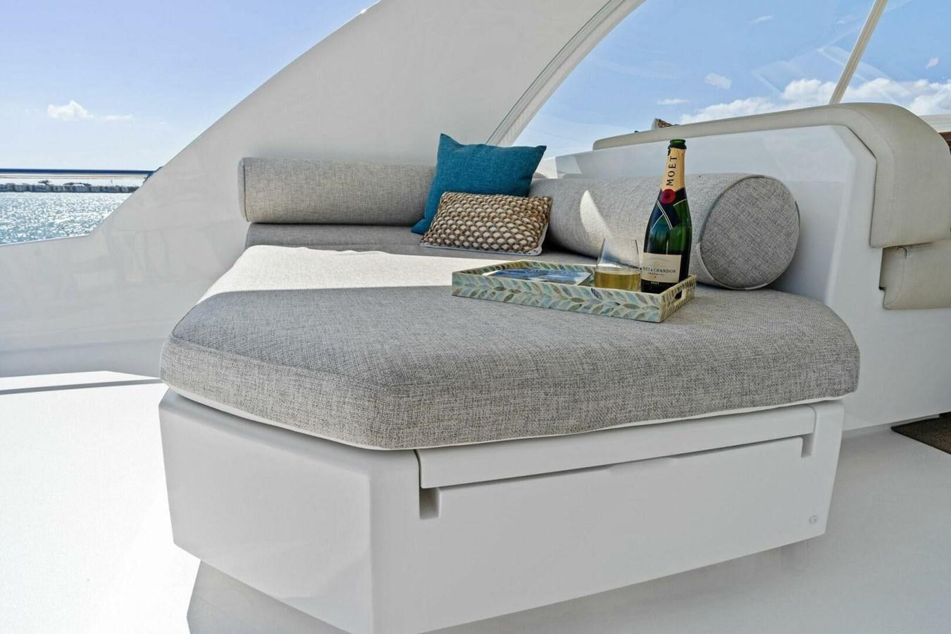 a couch with pillows and a bottle on it aboard MANA Yacht for Sale