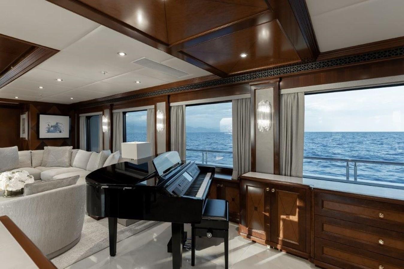 a room with a bed and a piano aboard IRON BLONDE Yacht for Sale