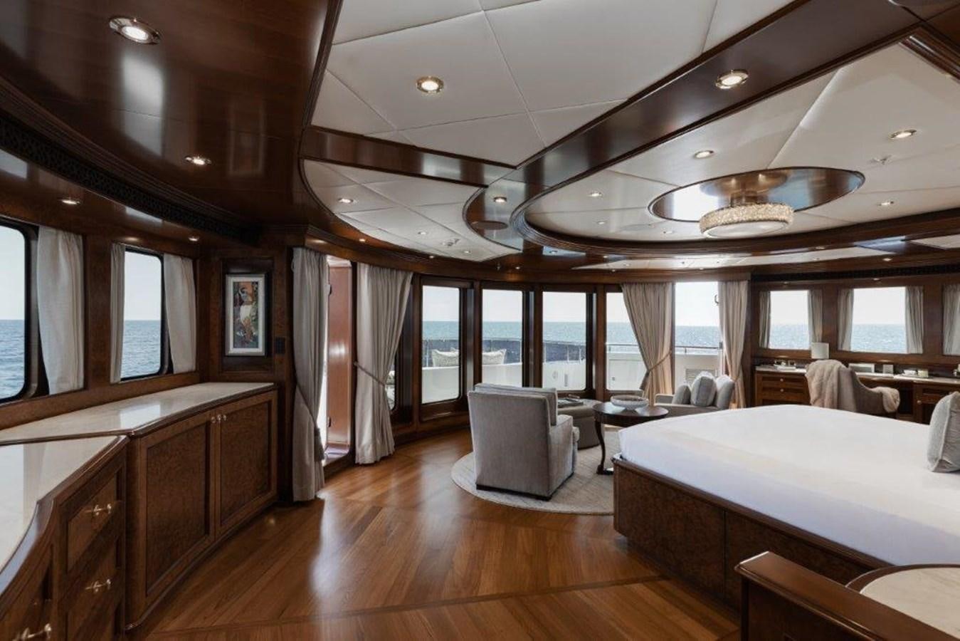 a room with a bed and a table and chairs aboard IRON BLONDE Yacht for Sale