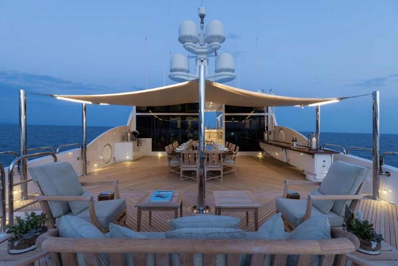 a lounge area with a large lounge chair and a large white awning aboard IRON BLONDE Yacht for Sale