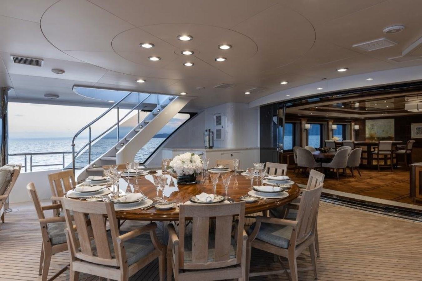 a dining room with a large body of water in the background aboard IRON BLONDE Yacht for Sale