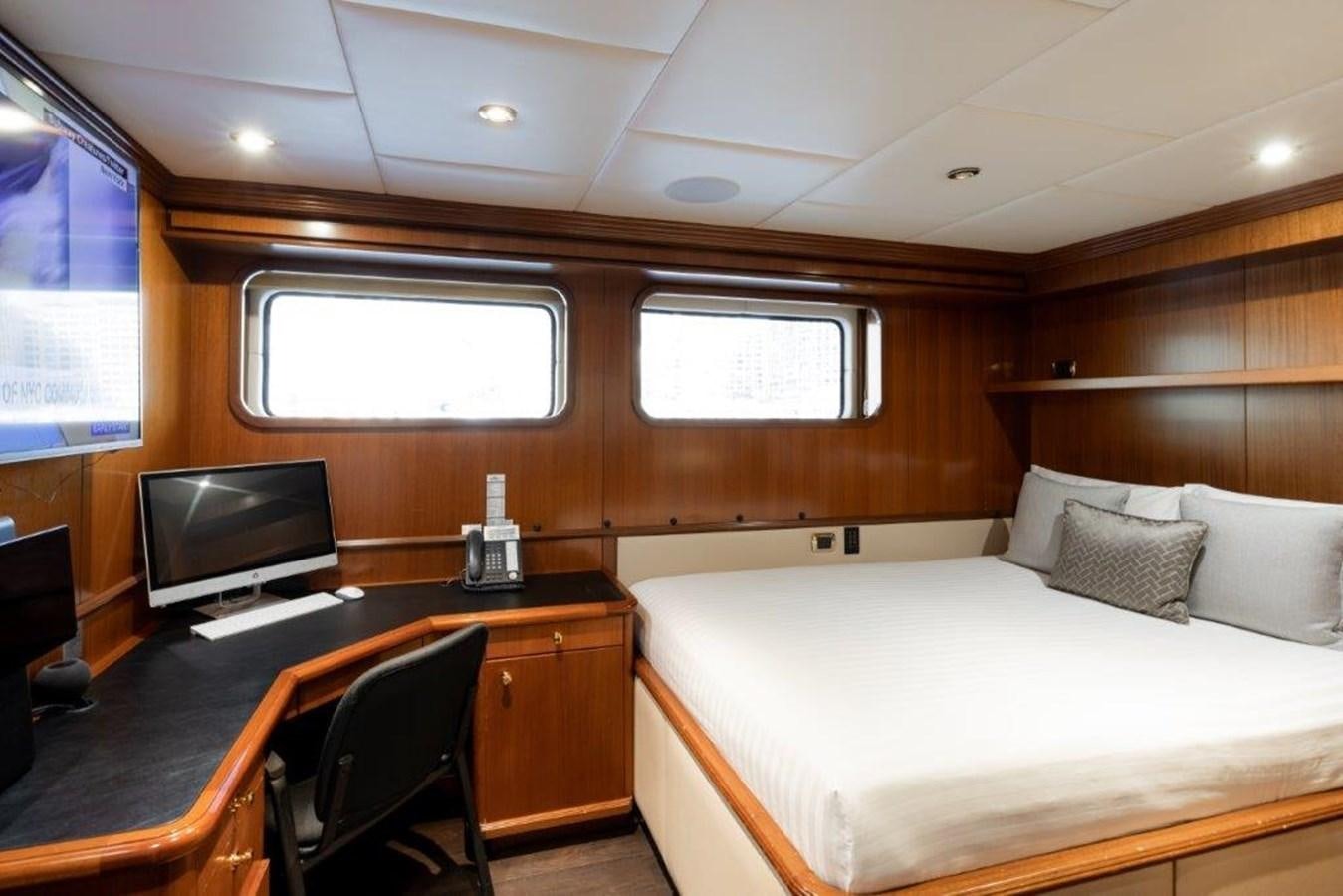 a room with a bed and a desk aboard IRON BLONDE Yacht for Sale