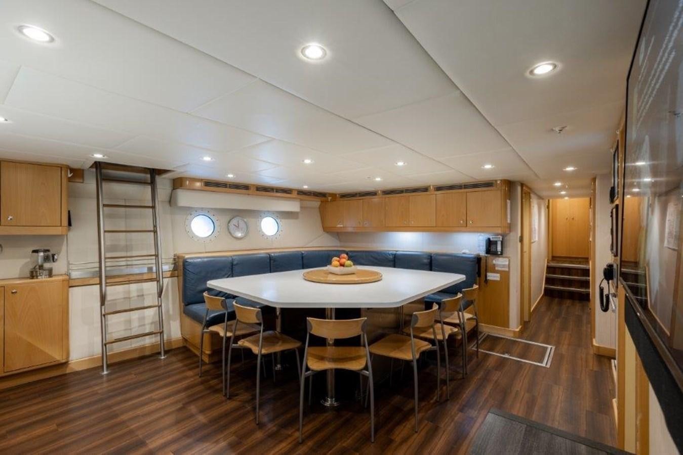 a kitchen with a table and chairs aboard IRON BLONDE Yacht for Sale
