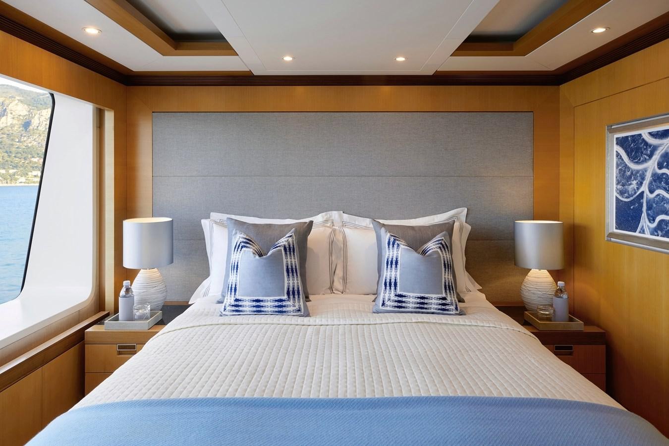 a bed with a blue and white bed spread aboard LA BLANCA Yacht for Sale