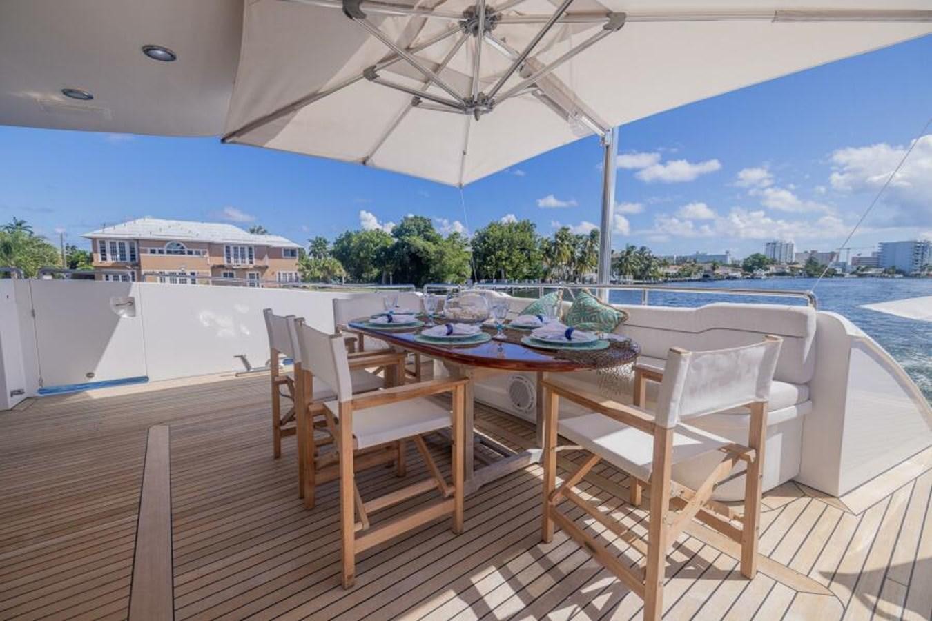 a table and chairs on a patio aboard ENTOURAGE Yacht for Sale