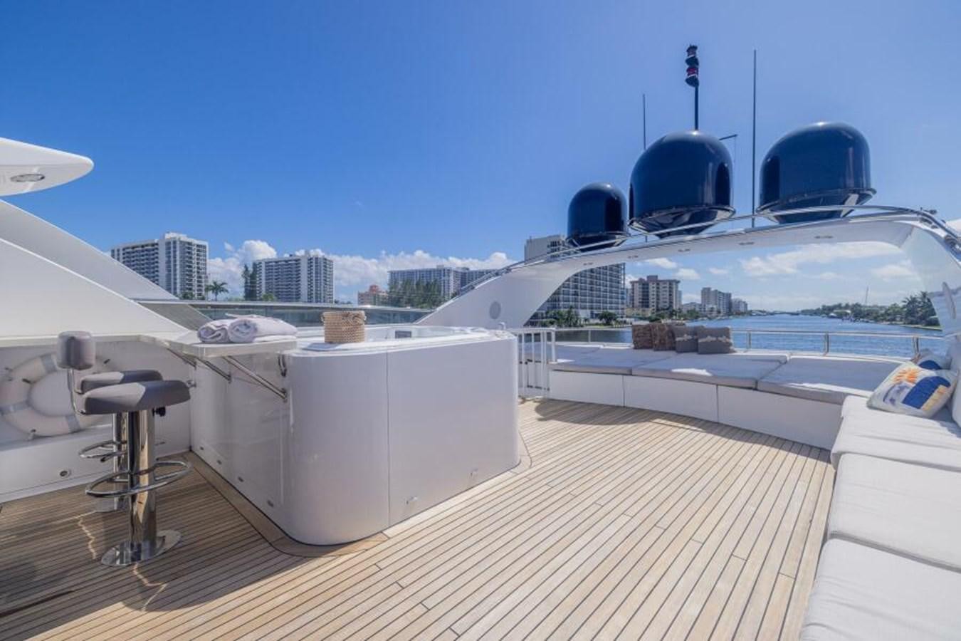 a deck with a view of a city and a large ship aboard ENTOURAGE Yacht for Sale