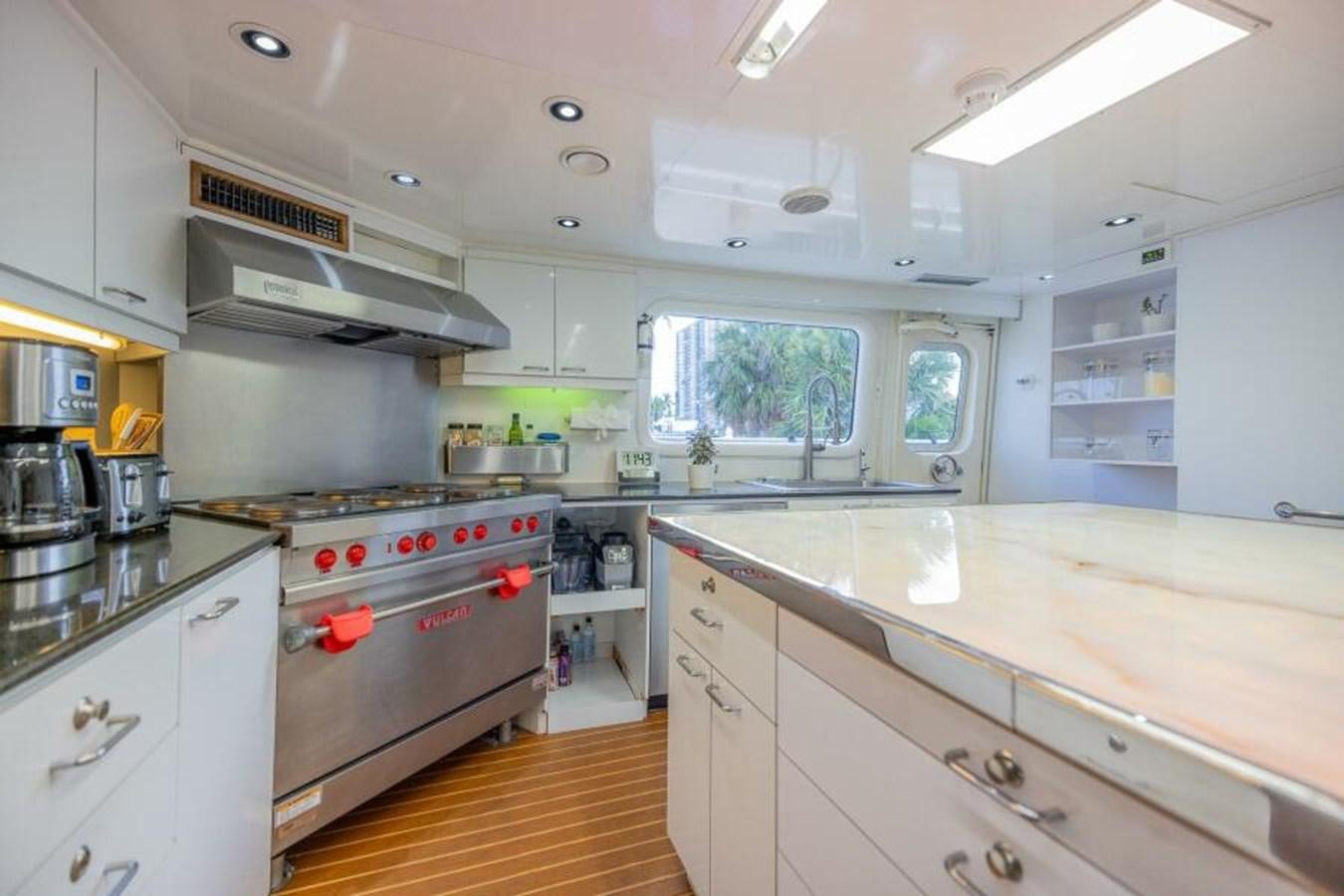 a kitchen with white cabinets aboard ENTOURAGE Yacht for Sale