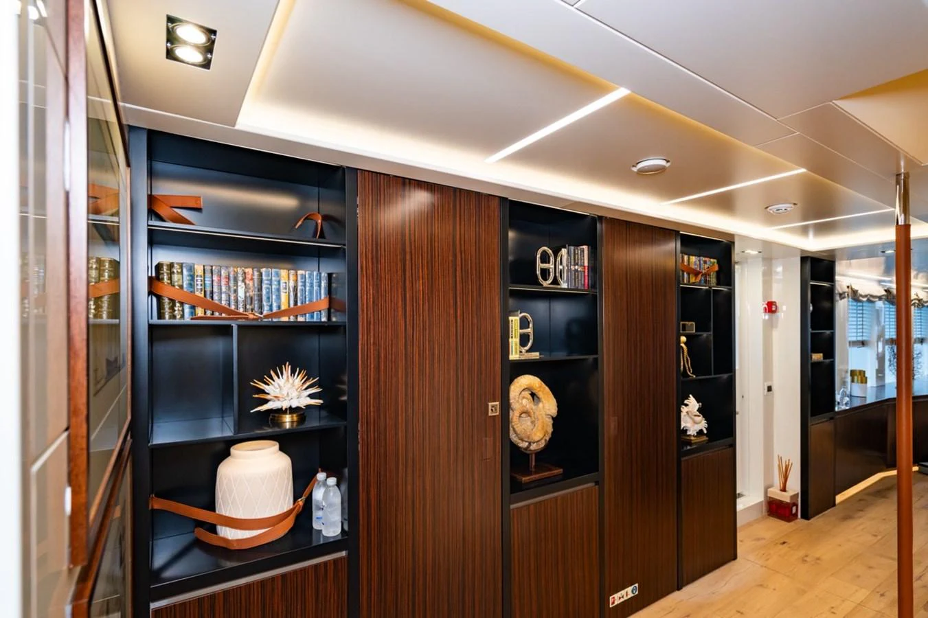 a room with a wood cabinet and shelves with objects on it aboard K584 Yacht for Sale