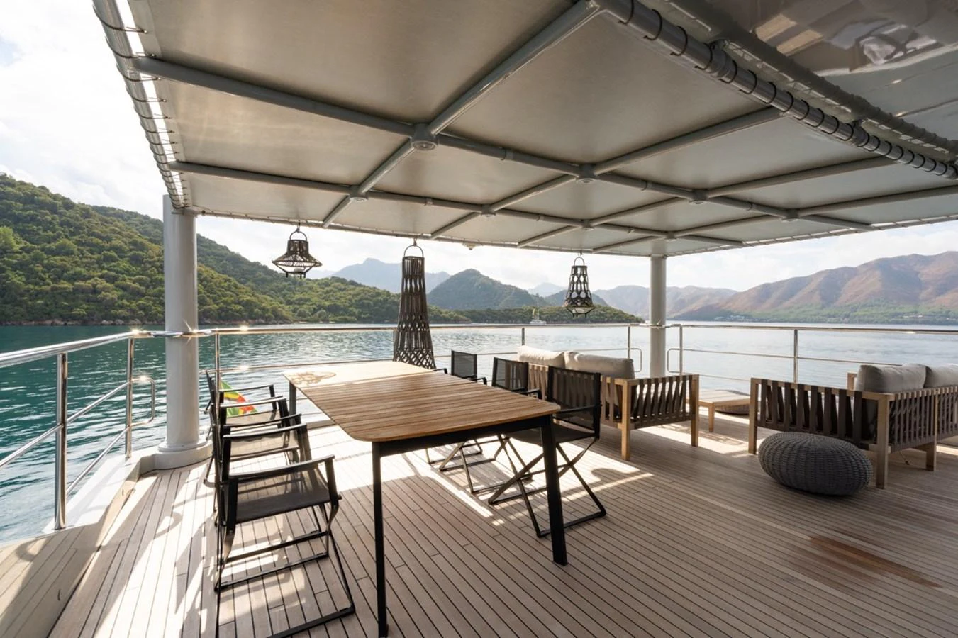 a table and chairs on a deck overlooking a body of water aboard K584 Yacht for Sale