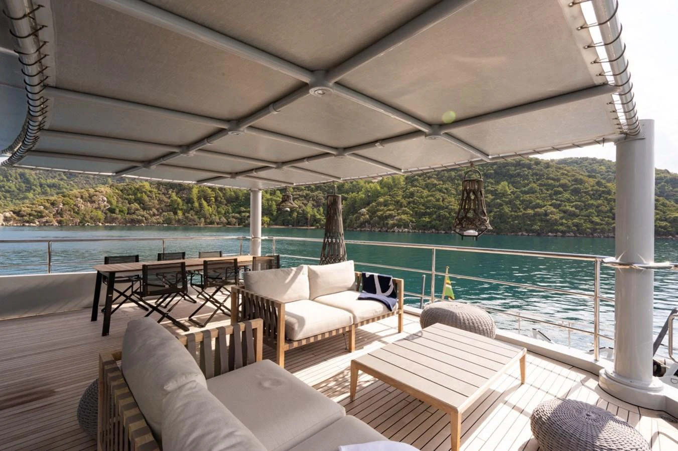 a patio with a large body of water and a large patio with a large white table and chairs aboard K584 Yacht for Sale