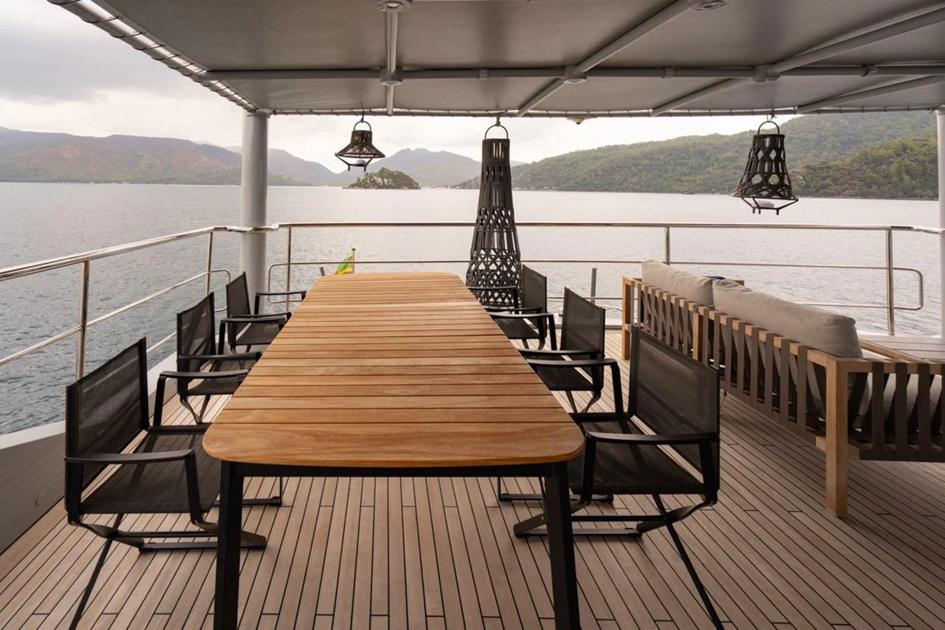 a table and chairs on a deck overlooking a body of water aboard K584 Yacht for Sale