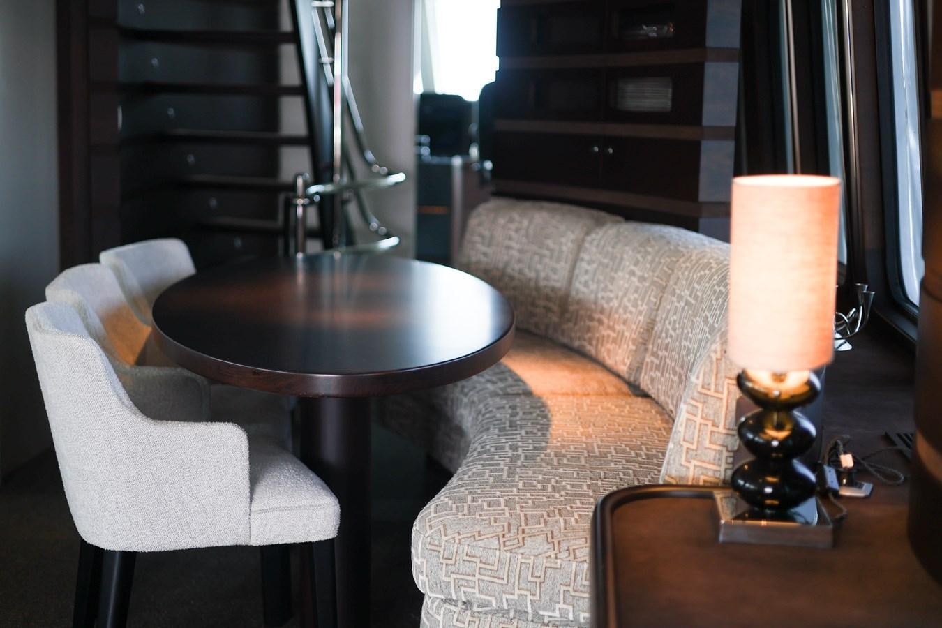 a living room with a table and a lamp aboard NASHIRA Yacht for Sale